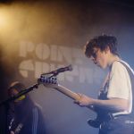 Declan McKenna sur scène avec une guitare